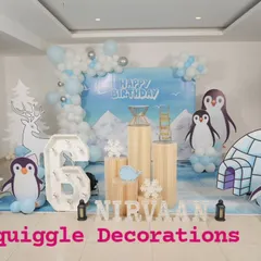 A cool and unique penguin-themed 6th birthday party. I created a winter scene with an igloo cutout, penguin characters, and a balloon garland in shades of icy blue and white.