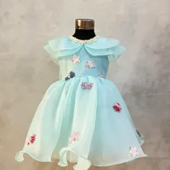 Another view of this custom aqua organza dress, highlighting the delicate collar and whimsical star embellishments.