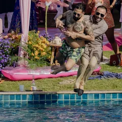 Two guests joyfully jump into the pool during a fun-filled pre-wedding party at the Sheraton Hua Hin, Thailand.