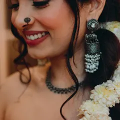 A close-up on this bride-to-be's happy smile during her Mehendi. The look is natural and fresh, with a focus on her radiant skin, a pretty nose pin, and statement jhumkas.