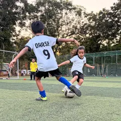 A player skillfully shields the ball from a defender during a match, demonstrating the strength and ball protection skills we teach.