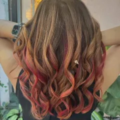 Flaming with style. This look features a mix of red and copper tones on a brown base, all achieved without bleach for a warm, fiery effect.