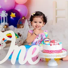Before the delightful mess begins, we capture a sweet portrait with the "One" sign and a pristine cake. It's the calm before the fun storm.