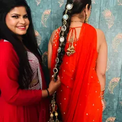Me helping a client style the mirror-work parandi with her orange suit. It shows how these accessories can be incorporated into a complete look.