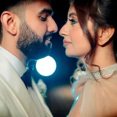 An intimate close-up where the focus is entirely on the couple's connection. The soft background light highlights their profiles, creating a romantic and dreamy mood for this engagement portrait.