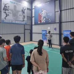 A group of my students listening intently as I explain the features of a new racket during the Yonex Demo Day. I believe in educating my players about their equipment to help them make informed choices.