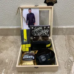 The final look of the wooden birthday box hamper for him. It includes a wallet, belt, sunglasses, chocolates, and a personal photo, making it a complete and thoughtful gift.