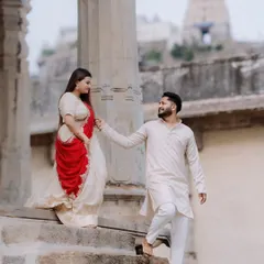 Against the grand, carved stone pillars of a Melukote temple, a couple dressed in traditional attire shares a quiet look. This image showcases a timeless, heritage-themed pre-wedding portrait.