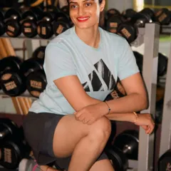 Confidence is built through consistency. Taking a moment to rest by the dumbbell rack, feeling strong inside and out.