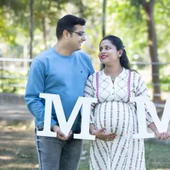 The shared look between two people about to become three. This candid shot with "MOM" letters captures the quiet understanding and excitement of the parents-to-be.