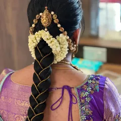 A classic bridal braid, woven with gold thread and adorned with jasmine flowers. This is a timeless hairstyle that is always in demand, and a valuable skill for any bridal artist.