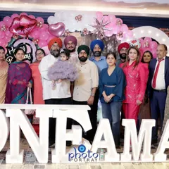The entire family gathers for a group photograph at a first birthday celebration in Delhi. I am experienced in organizing and shooting large group portraits during busy events.