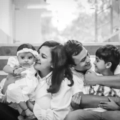 A family cuddle on the stairs. Black and white enhances the intimacy of this moment, focusing on the expressions and embrace.
