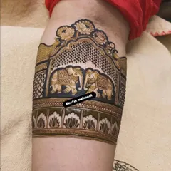 A close-up of an arm band featuring two beautifully detailed elephants facing each other under an ornate arch, a powerful and popular bridal motif.