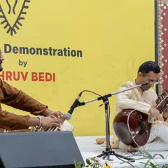 Performing alongside a Tabla artist during a lecture-demonstration. The interplay between Sitar and Tabla is central to a complete Hindustani classical performance, providing the rhythmic foundation.