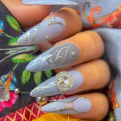 A close-up of our Navratri-themed grey nail art. This design combines a soft grey base with silver chrome lines, glitter, and a stunning 3D crystal embellishment.