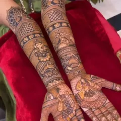 A beautiful design featuring Ganesha and other deities, with intricate patterns filling the arms up to the elbow.