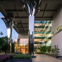 The entrance courtyard of the Stainless Steel Office, where our faceted steel columns frame the main entrance, demonstrating how we integrate bold architectural features with landscape design.