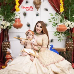 A beautiful moment between mother and son in our elegant white Janmashtami setup. The little one, dressed as Krishna with his flute, looks so serene in his mother's arms.