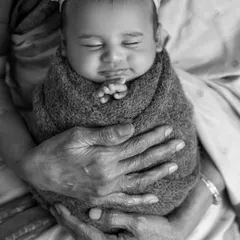 A truly special moment capturing four generations of love. This black and white portrait of a great-grandmother holding her newborn great-grandchild is a powerful and priceless family heirloom.