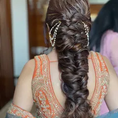 The bride's bhabhi, all ready for the D-day with this intricate and voluminous fishtail braid, adorned with a traditional passa.