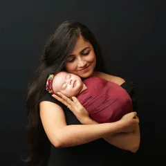 A mother's gentle embrace. This portrait of a mom holding her newborn daughter close to her heart is a timeless expression of maternal love.