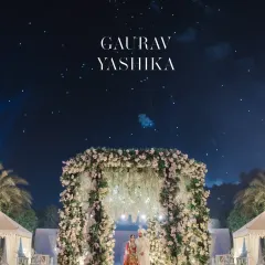 A magical, almost surreal portrait of the couple under a floral arch and a starry night sky. This image was edited to create a fairytale-like, dreamscape effect.