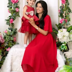 A classic portrait of a mother and daughter in a beautiful floral setting. Their coordinating outfits and happy smiles make this a timeless keepsake.