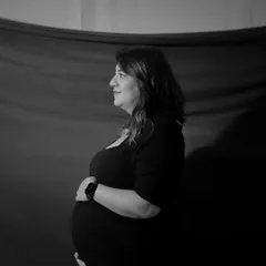 A classic black and white profile shot. The dramatic lighting sculpts the form, creating a timeless and emotional portrait of the mother-to-be.