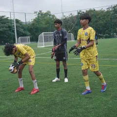 Our young goalkeepers ready for a handling drill. This image captures the focus and camaraderie within our goalkeeping unit as they prepare to work on their catching and ball control.
