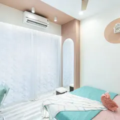 This view shows the full-length wardrobe with an arched mirror, adding a touch of elegance and making the room feel more spacious. The color-blocked wall in a soft peach tone adds warmth.