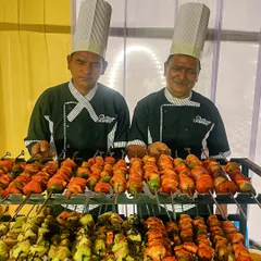 My chefs are ready to serve freshly grilled delights from the live barbeque counter. Here they are presenting a colourful array of perfectly marinated and charred paneer tikka skewers, a guaranteed hit at any celebration.