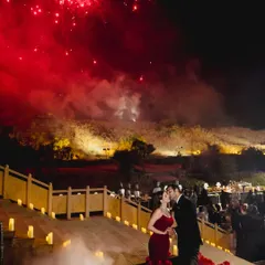 A cinematic moment from a Jaisalmer reception, with the couple sharing a kiss as red fireworks light up the desert sky. The design here was about creating epic, unforgettable memories.