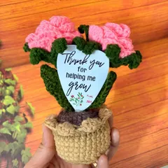 A hand-held view to show the scale of my 7-inch tall crochet flower pot. It's the perfect size for a desk, shelf, or bedside table, adding a touch of handmade charm.