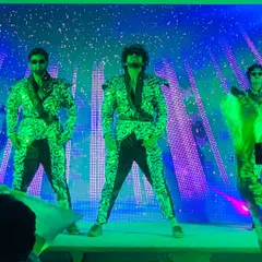 Our male dancers striking a powerful pose in reflective green and black costumes during a corporate show in Dandeli. The coordinated outfits and confident stage presence are hallmarks of our professional dance troupe for company events.