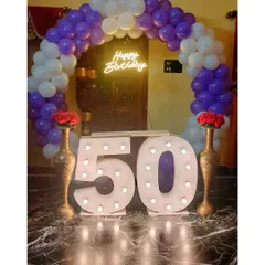A family celebrating a 50th birthday with our marquee number setup. The large, lit-up "50" provides the perfect centerpiece, framed by a purple and white balloon arch for a festive and memorable family photo.