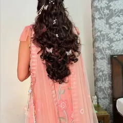 A beautiful Mehendi hairstyle with butterfly and pearl accessories woven into a voluminous braid. This is perfect for a whimsical and romantic pre-wedding look.