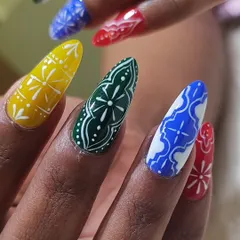 A macro shot showing the precision of my hand-painted line work. This Navratri design features traditional patterns in bold, festive colors on long coffin nail extensions.