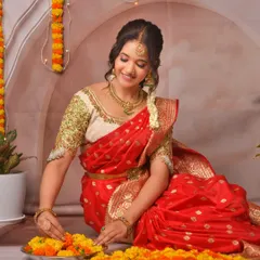 A client looking beautiful while arranging a flower rangoli for Diwali, dressed in a traditional red silk saree from my collection.