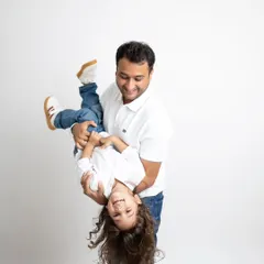 Pure fun! A father playfully holding his son upside down, resulting in a genuine, joyful laugh.