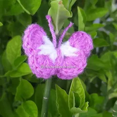 A delicate crochet butterfly in purple and white. These can be used as decorative elements on bouquets, as hair clips, or attached to a keychain.