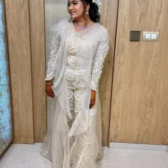 The full view of the client's stunning all-white ensemble, with her hair pulled back into a stylish ponytail.