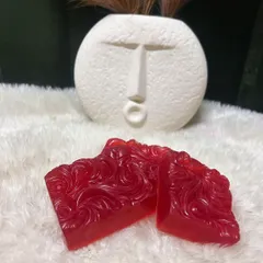A pair of my handcrafted Red Wine soaps, with their rich color and intricate design. They make a luxurious addition to any bathroom.