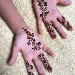 A simple and pretty floral vine design on the palms of a child's hands.