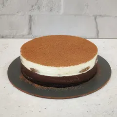 My Tiramisu Cheesecake, a perfect blend of coffee and cream. This cake has a rich chocolate and coffee base, a creamy cheesecake layer, and is dusted with cocoa powder.