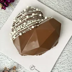 A modern twist on a romantic cake. This geometric, heart-shaped piñata cake is made of solid chocolate that you can smash open to reveal a surprise inside. It's a fun and interactive dessert for any celebration.