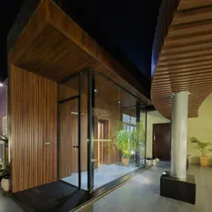 The entrance to a terrace area, designed with a glass enclosure and warm wood paneling. This structure creates a seamless transition from the interior to the outdoor space while maintaining a modern architectural aesthetic.