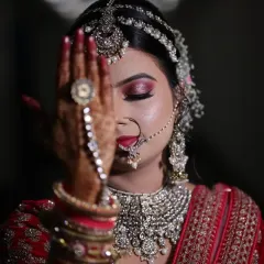 The details make the look. This artistic shot highlights the intricate eye makeup, the beautiful nath (nose ring), and the detailed hathphool (hand jewelry), all essential elements of a traditional bridal look.