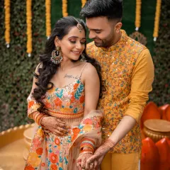 A sweet, intimate moment between the couple during their Haldi ceremony, their coordinated outfits adding to the festive atmosphere.