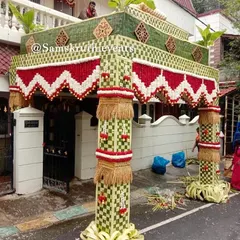 A grand Chappra design for a housewarming. This elaborate entrance structure is built with woven coconut leaves and decorated with red and white floral patterns, creating an impressive welcome for your guests.